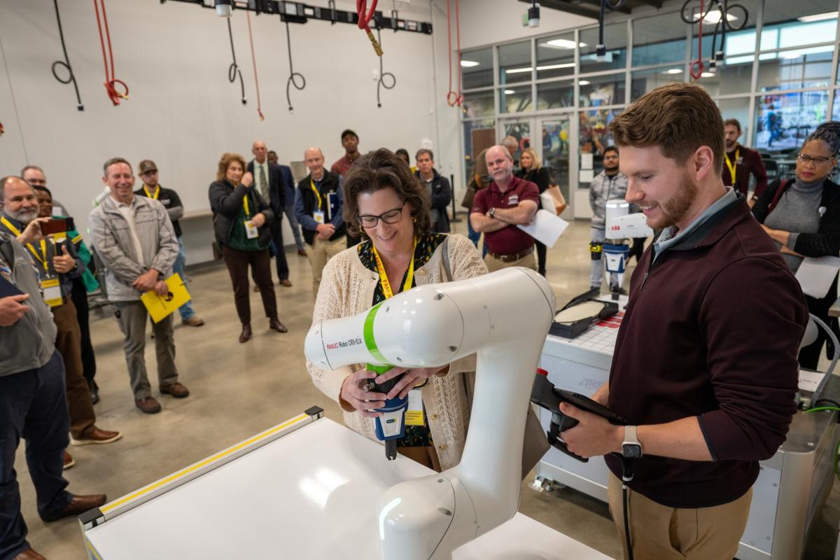 Researchers examine a robotic arm